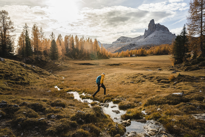 man walking over river field